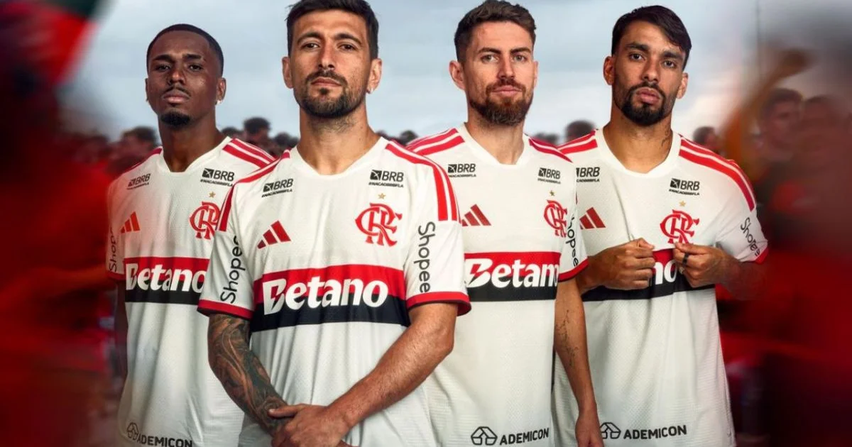 Ilustração de estádio: jogador de costas com uniforme branco Manto 1 Branco do Flamengo, torcida com faixas vermelhas e pretas, confete e luzes.