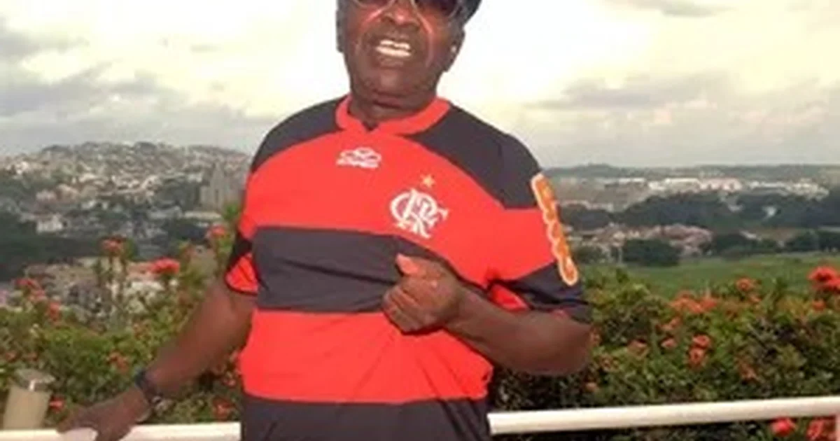 Estádio vazio ao entardecer, camisa retrô em assento e corredor de hospital ao fundo — homenagem ao ídolo do Flamengo internado.