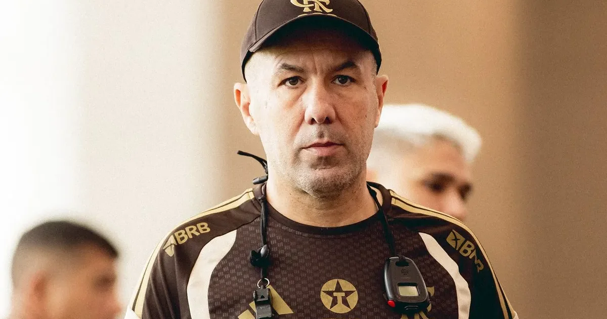 Zagueiro argentino em ação no estádio à noite, scouts observando; imagem sobre monitoramento do Flamengo como possível reforço.