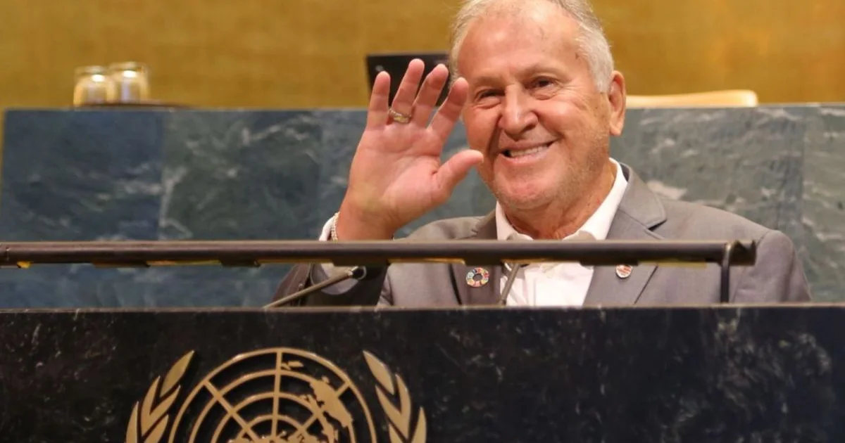 Delegação do Flamengo em frente à sede da ONU, bola se transforma em globo com símbolos dos ODS; clima diplomático e cores rubro-negras.