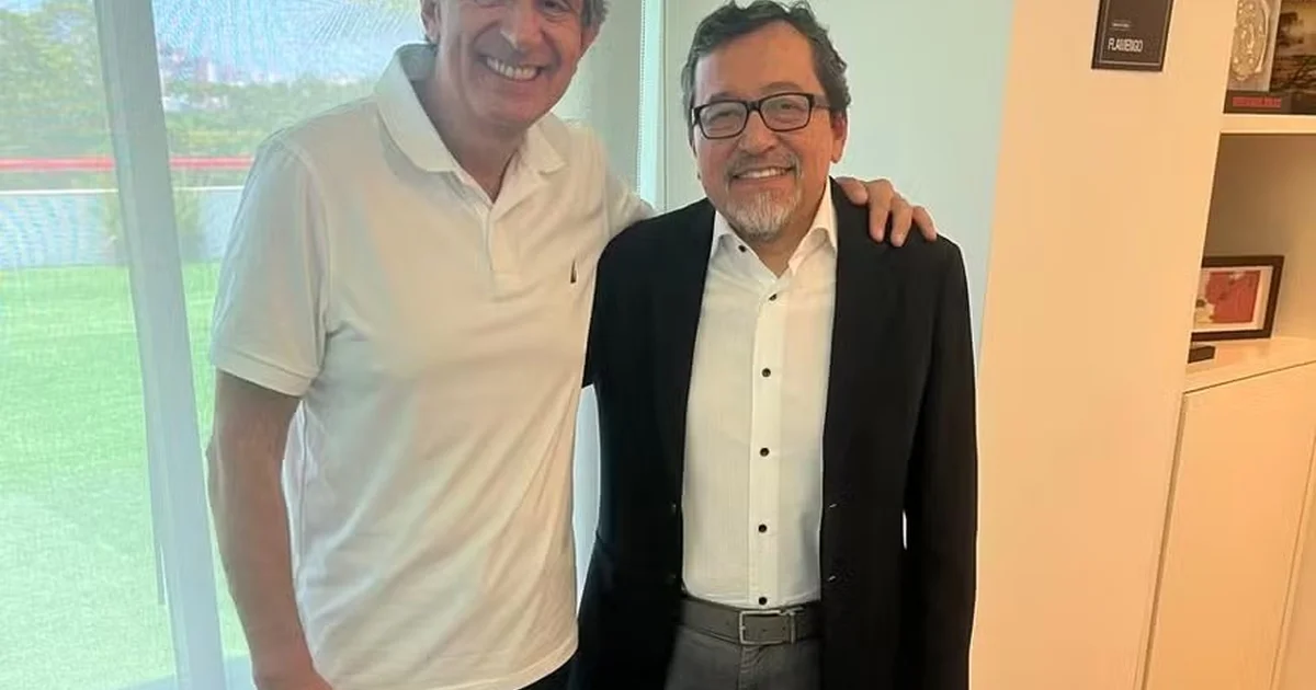 Representantes de Flamengo e Bahia negociam cotas de transmissão em mesa, com estádio, câmeras e contratos ao fundo.