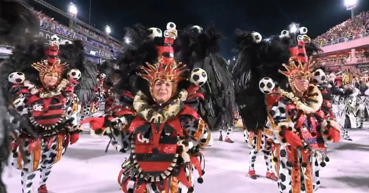 Desfile da Viradouro com elementos do futebol em cores rubro-negras, bateria, alegoria e multidão celebrando o título do Carnaval.
