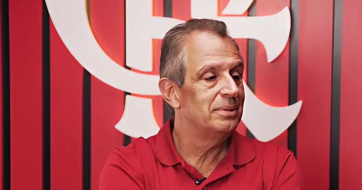 Estádio ao entardecer com moeda partida e dirigentes anônimos, simbolizando crise do Flamengo e disputa na Libra por receitas e transmissão