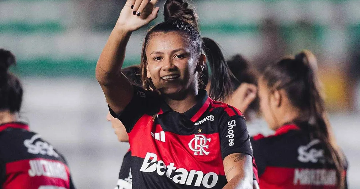 Jogadoras em camisetas vermelho e preto comemoram vitória por 3 a 1 no estádio, torcida e placar ao fundo — Campeonato Brasileiro Feminino.