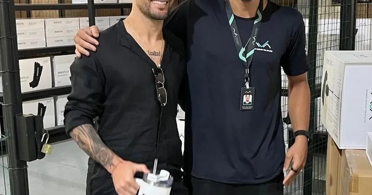 Torcedor do Flamengo desaba em choro ao encontrar jogador, amparado por amigos no local de trabalho, cena emocionante registrada em vídeo.