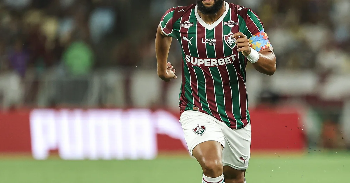 Ilustração do Maracanã ao entardecer: torcedores divididos, ato de jogo com placar 2x1 e elementos de debate sobre mudança de data do clássico.