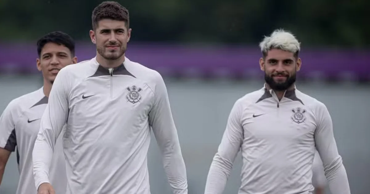 Atacante genérico em disputa aérea no estádio ao pôr do sol; silhuetas de dirigentes e contrato sugerem empréstimo entre Vitória e Flamengo.