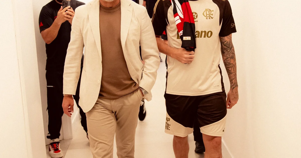 Ilustração editorial: vestiário tenso do Flamengo, diretor saindo, jogadores abatidos, clima de crise e arquibancada chuvosa ao fundo.