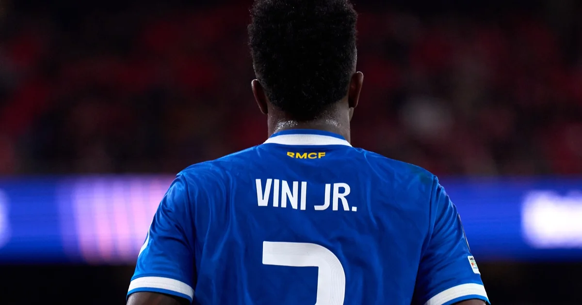 Estádio e Câmara conectados pela campanha contra o racismo, jogador simbólico em ação, torcida com cartazes e clima de urgência