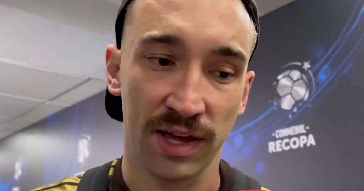 Zagueiro do Flamengo de costas no Maracanã após derrota, torcida desfocada e clima tenso