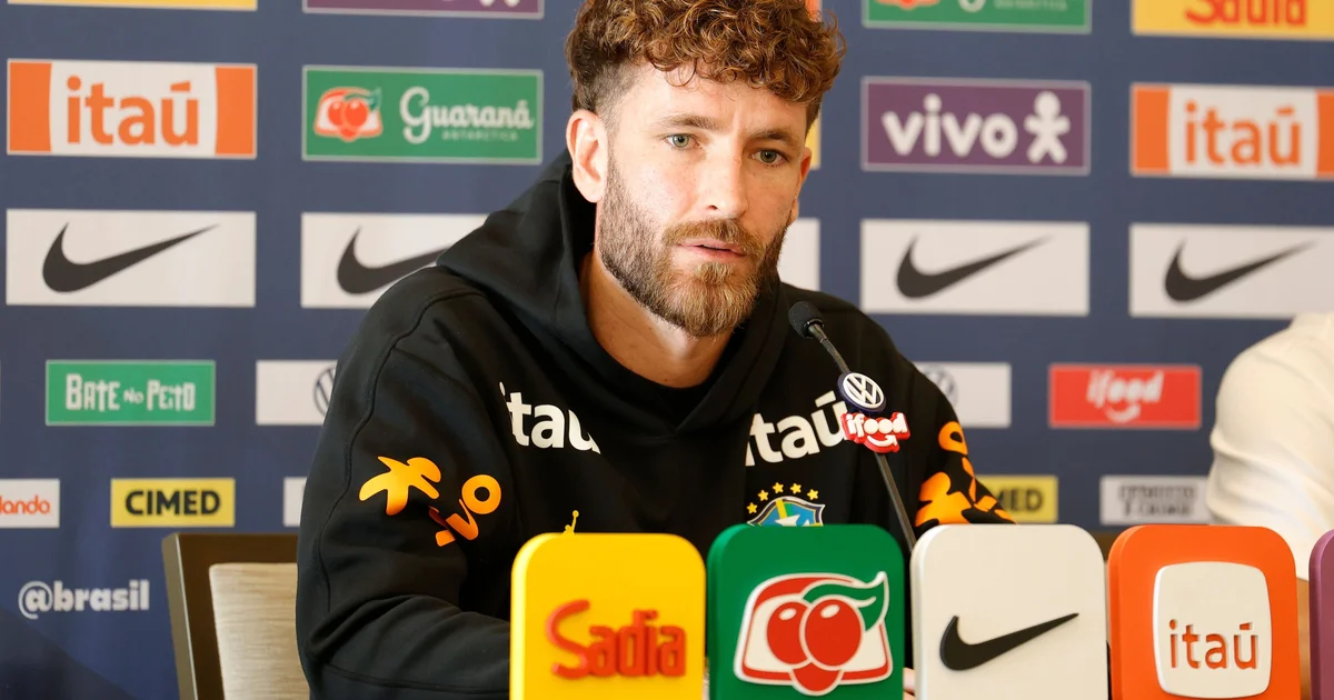 Ilustração editorial: Léo Pereira em estreia pela seleção, zagueiro de amarelo no lance decisivo, derrota 2 a 1, estádio e torcida.