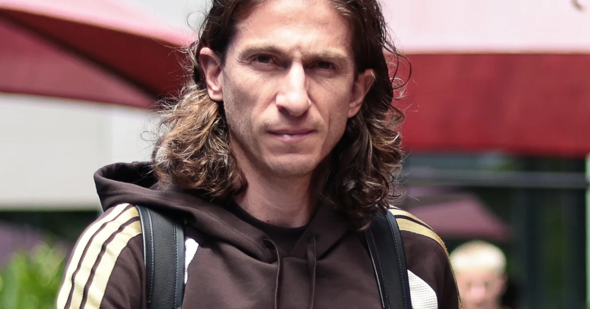 Ilustração editorial de zagueiro orientado por veterano à beira do campo, estádio lotado e atmosfera de convocação — Léo Pereira, influência de Filipe Luís