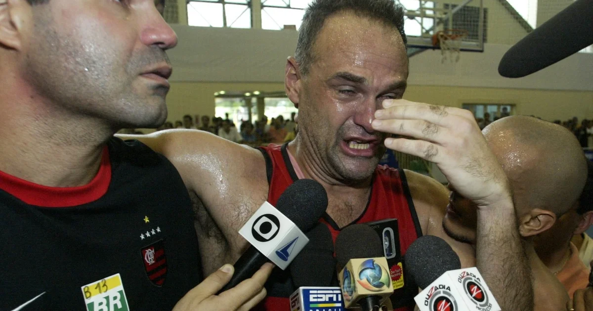 Ilustração de homenagem: estádio com quadra de basquete iluminada, torcida com velas e cores rubro-negras, homenagem a Oscar Schmidt.