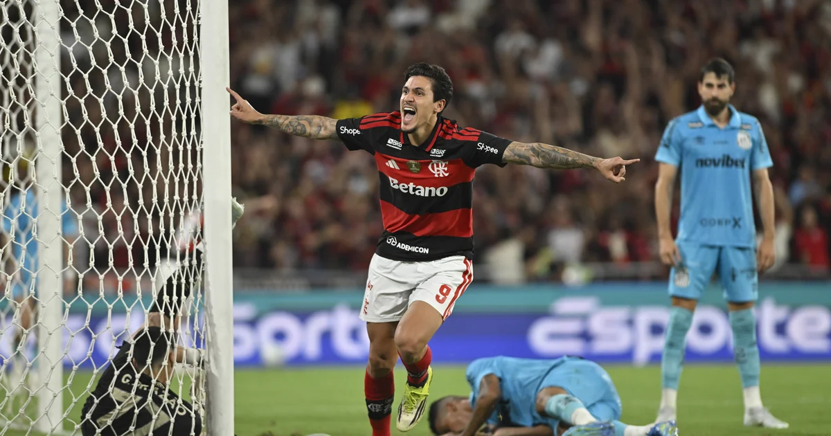 Atacante em alta no Flamengo celebrando gol em clássico, estádio lotado, cores rubro-negras e torcida vibrando.