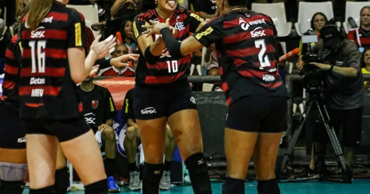 Time feminino de vôlei em uniformes vermelho e preto comemorando vitória na Superliga, quadra e placar 3-0 visíveis.