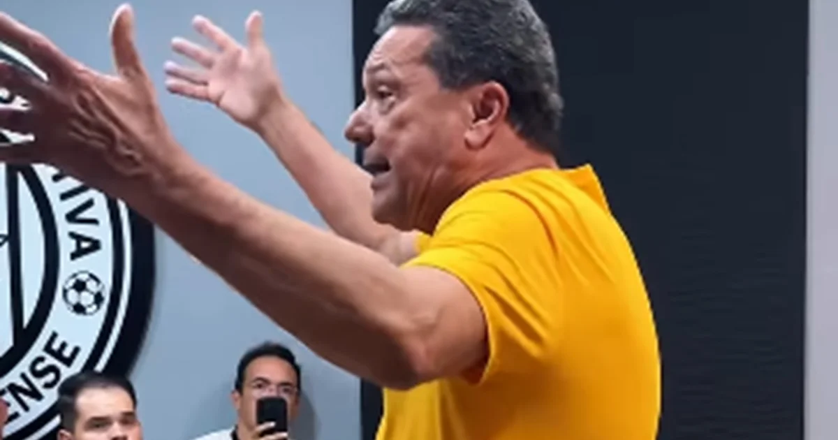 Treinador veterano ministrando palestra no CT Noel Alves, elenco do clube alagoano reunido no gramado ao entardecer