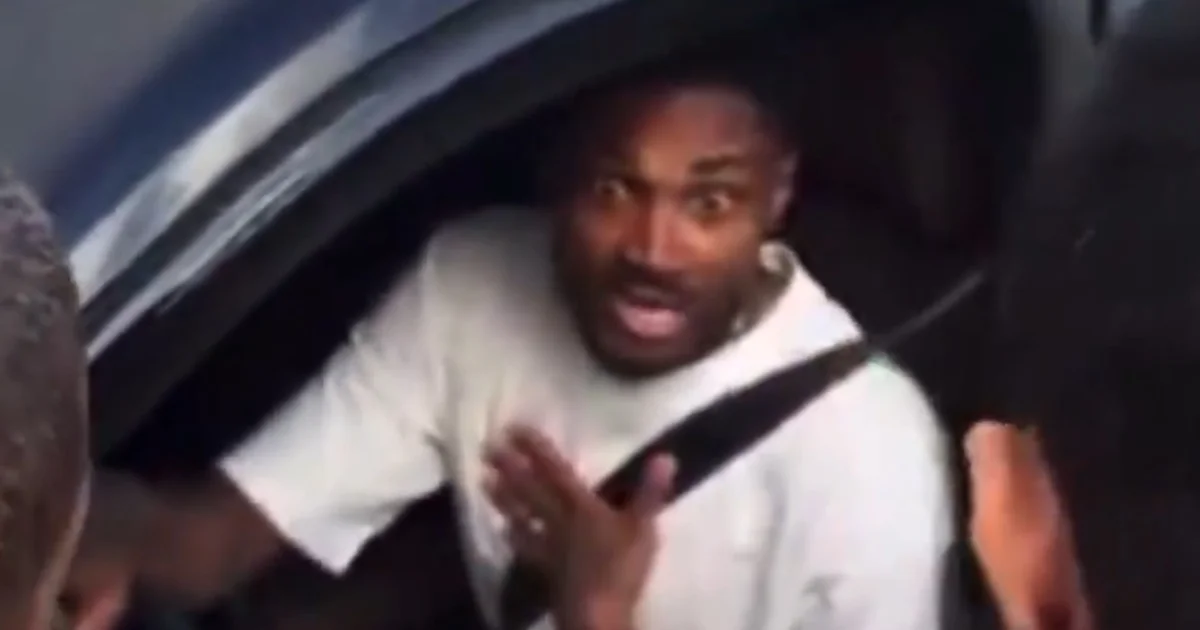 Cena no CT: carro cercado por dezenas de torcedores em protesto, jogador confrontado, atmosfera tensa e segurança presente