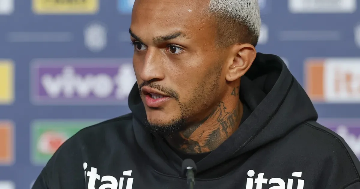 Jogador anônimo de costas com camisa amarela em estádio da Copa, multidão desfocada e atmosfera de pressão da Seleção.